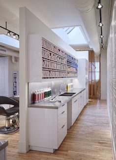 a white kitchen with lots of counter space next to a wall mounted art work on the wall