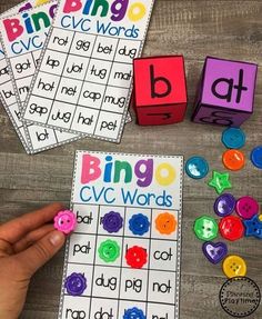 a person is playing with some colorful dices on the table next to their name cards