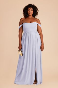 a woman in a blue dress with an off the shoulder top and slited skirt