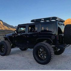 a black jeep is parked in the desert