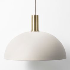 a white and gold colored light hanging from a ceiling fixture in a room with no walls