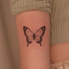 a woman's arm with a butterfly tattoo on the left side of her body