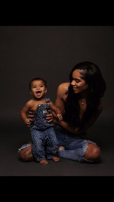 a woman is holding a baby in her lap and posing for the camera with it's mouth open