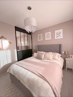 an image of a bedroom setting with pink and white decor on the walls, bed in center