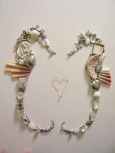 two seashells are attached to the side of a white wall with a heart