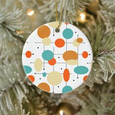 an ornament hanging from a christmas tree decorated with colorful circles and dots on it