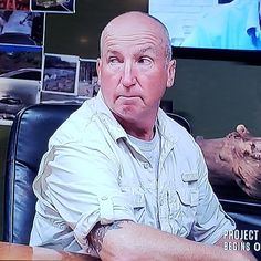 a man sitting at a desk in front of a tv screen with the words project manager on it