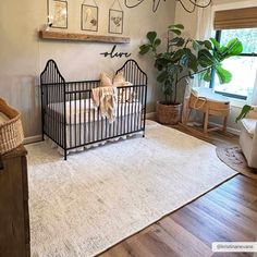 a baby crib in the corner of a room with pictures hanging on the wall