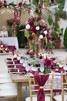 the table is set with wine glasses and flowers