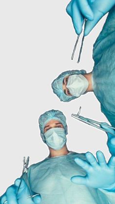 two surgeons in blue scrubs are performing surgery