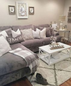 a living room with gray couches and white rugs on the floor in front of two framed pictures