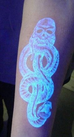 a person with a glow sticker on their arm that has an image of a snake