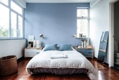 a bedroom with blue walls and wooden floors