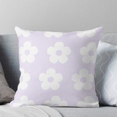 a purple and white pillow sitting on top of a couch