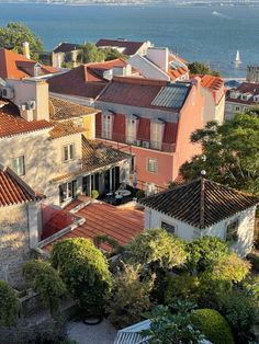 an aerial view of some buildings and the ocean in the background with boats on the water