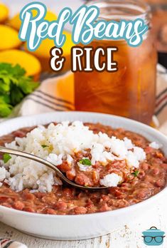 red beans and rice in a white bowl with a spoon next to lemons on the side