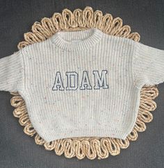 These gorgeous embroidered name sweaters are perfect for your little ones! These are machine embroidered by me. Sizes 0-6m to 4T. Sweaters are slightly oversized and have a chunky fit. Refer to measurements below. Main photo sweater color is SPECKLE with blue thread. Turnaround time is currently 1-2 weeks. VARSITY FONT 0-18m: MAX 6 letters 2T-4T: MAX 7 letters For these sweaters below, 18-24m is the same as 2T. Speckled White Mocha Peach Pink Dusty Blue Rose Pink Cream/Beige Lilac Measurements 0 White Cute Sweater With Embroidered Text, Personalized White Cotton Sweater, Cute White Sweater With Embroidered Text, Varsity Sweater With Letter Embroidery, Oversized Long-sleeved Sweater With Letter Embroidery, Baby Name Embroidery Sweater, Baby Sweater Embroidery Name, Embroidered Baby Name Sweater, Kids Jumpers