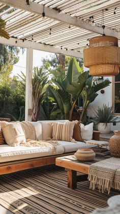 an outdoor living area with couches, tables and potted plants