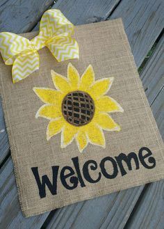 a welcome mat with a sunflower on it and a yellow bow tied to it