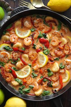 a skillet filled with shrimp and lemons