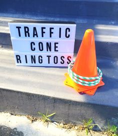 a traffic cone sitting next to a sign that says traffic cone ring tosses on it