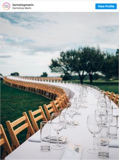 a long table is set with empty wine glasses