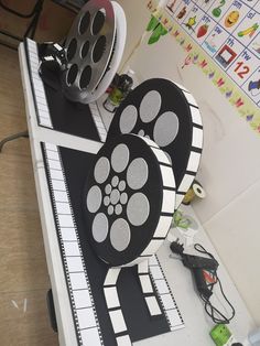 two black and white film reels sitting on top of a table next to a projector