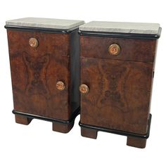 two wooden drawers with marble top and handles on each side, one has an animal design