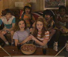 a group of people sitting around a bowl of food