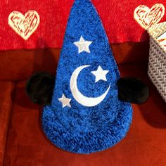 a blue hat with white stars and a crescent on the top is sitting on a couch