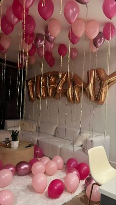 balloons and streamers are hanging from the ceiling in this living room decorated for a party