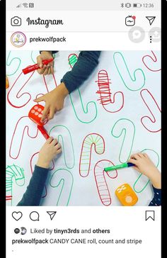 two children are drawing letters on a sheet of paper with crayons and markers