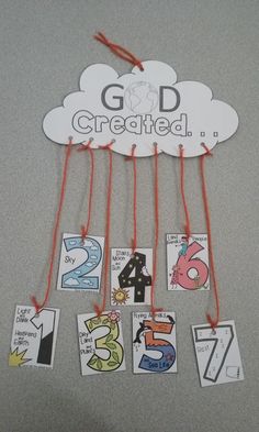 a group of cards hanging from strings with the words god created above them and below it is a cloud