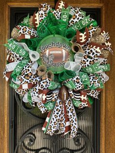 the wreath is decorated with green and white footballs, cheetah ribbons, and bottle caps