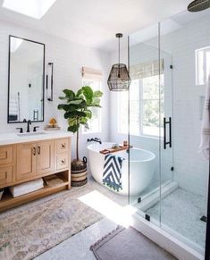 a bath room with a tub a mirror and a rug on the floor in front of it