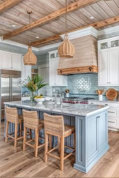 a kitchen with white cabinets and blue island in the center, surrounded by wicker bar stools