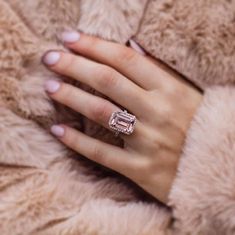 a woman's hand with a diamond ring on her finger and a fur coat