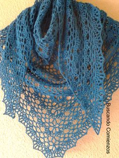 a close up of a blue shawl on a white wall with a beige background