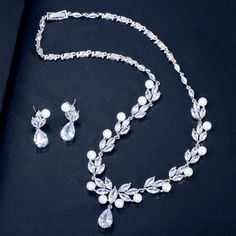 Adorned with iridescent pearls and intricately faceted cubic zirconia that capture the light from every angle with a perfectly translucent appeal, this beautiful bridal jewelry set is rhodium plated for a flawless finish which enhances the intricate detailing and conveys a modern take on old elegance. Necklace: 16.5" (approx. 42cm) long (if you would like it longer, please include a message at the time of order with the preferred length). Earrings: measure 1.2" long (approx. 3cm) and come with s Big Pearl Necklace, Beautiful Bridal Jewelry, Wedding Necklace Set, Bridal Wedding Earrings, Pearl Necklace Designs, Bridal Jewelry Set, Pearl Jewelry Wedding, Pearl Necklace Earrings, Big Pearl