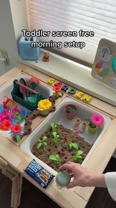 a child is playing with sand in the kitchen sink