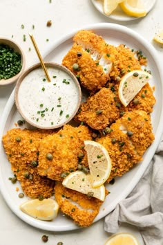 a plate with some fried food on it and dipping sauce in a bowl next to it