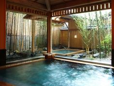 an indoor hot tub with bamboo trees in the background