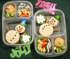 two plastic trays filled with food on top of a green table covered in writing