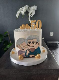 a 50th birthday cake with an image of two people on the side and gold hearts