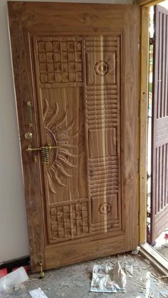 a wooden door sitting inside of a room next to a doorway with glass panels on it