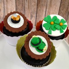 three decorated cupcakes sitting on top of a white plate