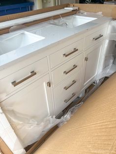 a bathroom vanity with two sinks in the middle of it being worked on by someone