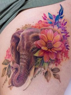 an elephant with flowers on it's back is depicted in this tattoo design by the artist