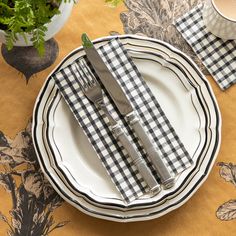 the place setting is set with black and white checkered napkins, silverware, and forks