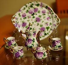 a tea set with purple flowers on it